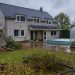 Maison individuelle après une tempête, avec un abri de jardin endommagé, une serre en polycarbonate et une piscine couverte dans le jardin.